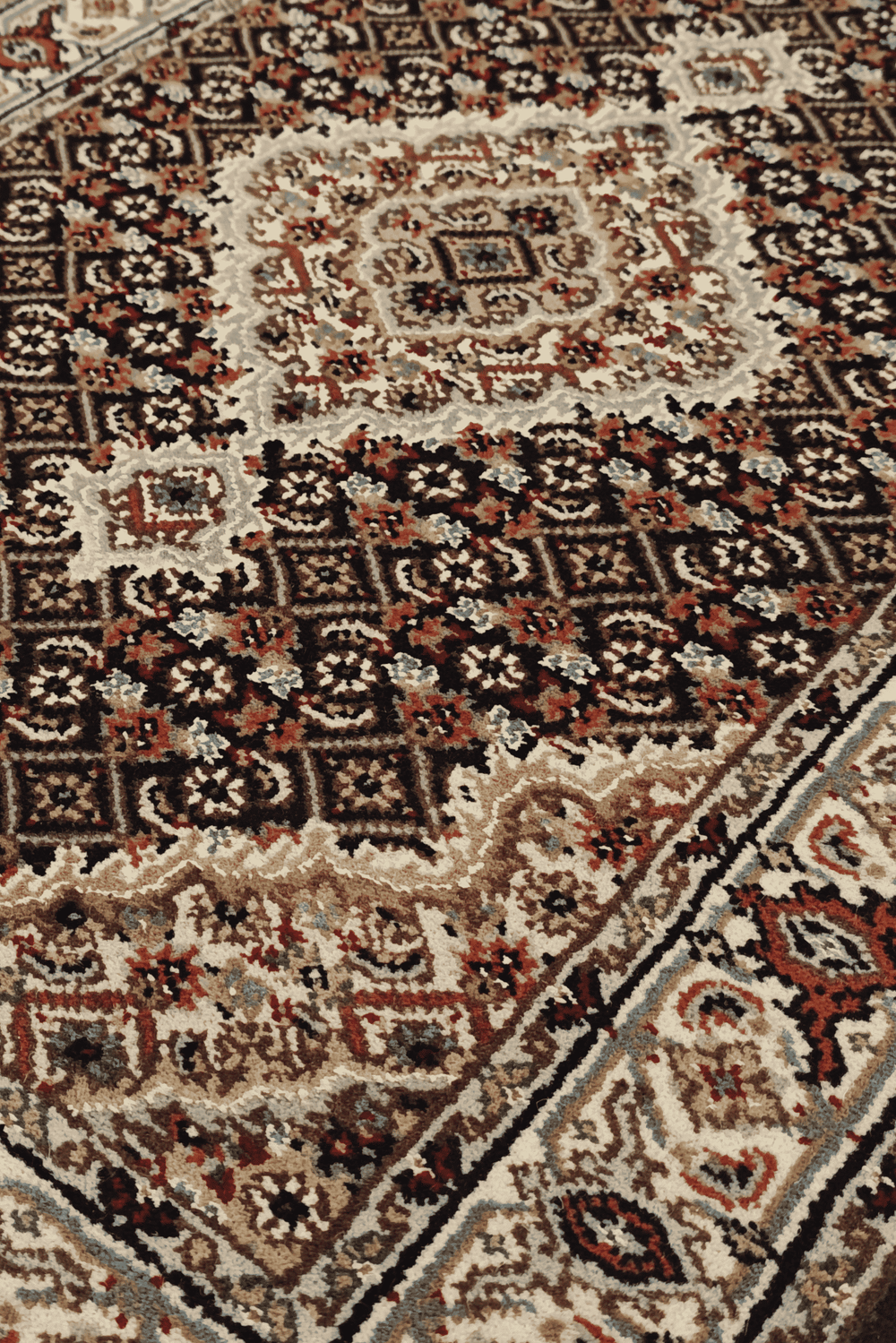 Mahi medallion detail in espresso and ivory on Tabriz rug
