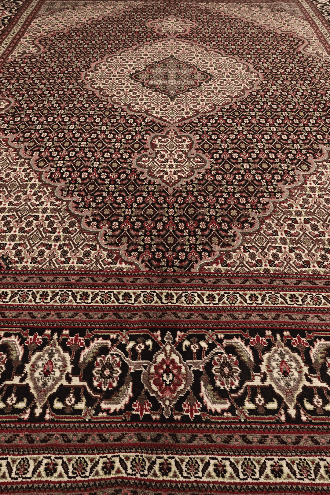 Fringe of burgundy mahi Persian Tabriz rug