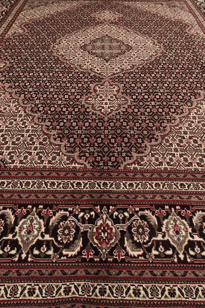 Fringe of burgundy mahi Persian Tabriz rug