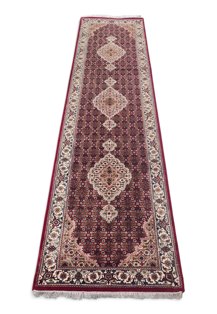 Border detail of deep red Tabriz hand-knotted runner